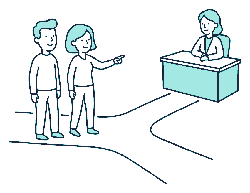 A couple pause where a footpath forks, one pointing down the branch toward an adviser waiting at a desk