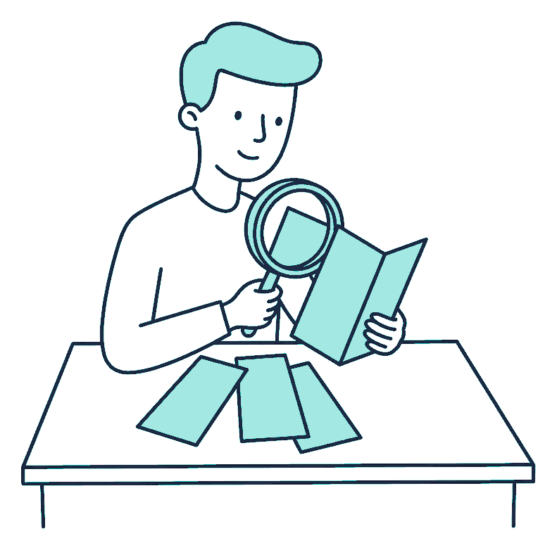 A person fans out three unmarked pamphlets on a desk and holds a magnifying glass over the middle one