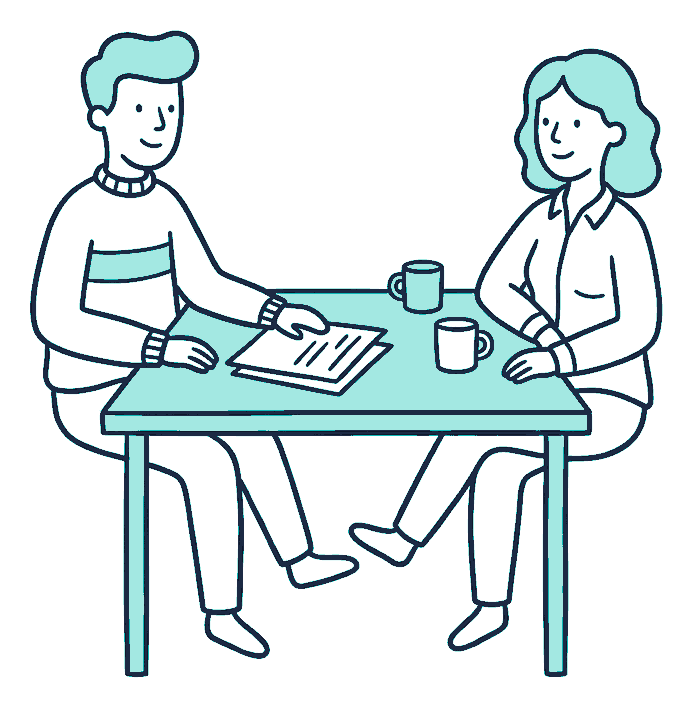 Two people sitting together at a kitchen table with one folded document between them