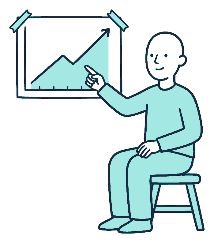 A person on a low stool points at a line chart taped to the wall, the line climbing year on year