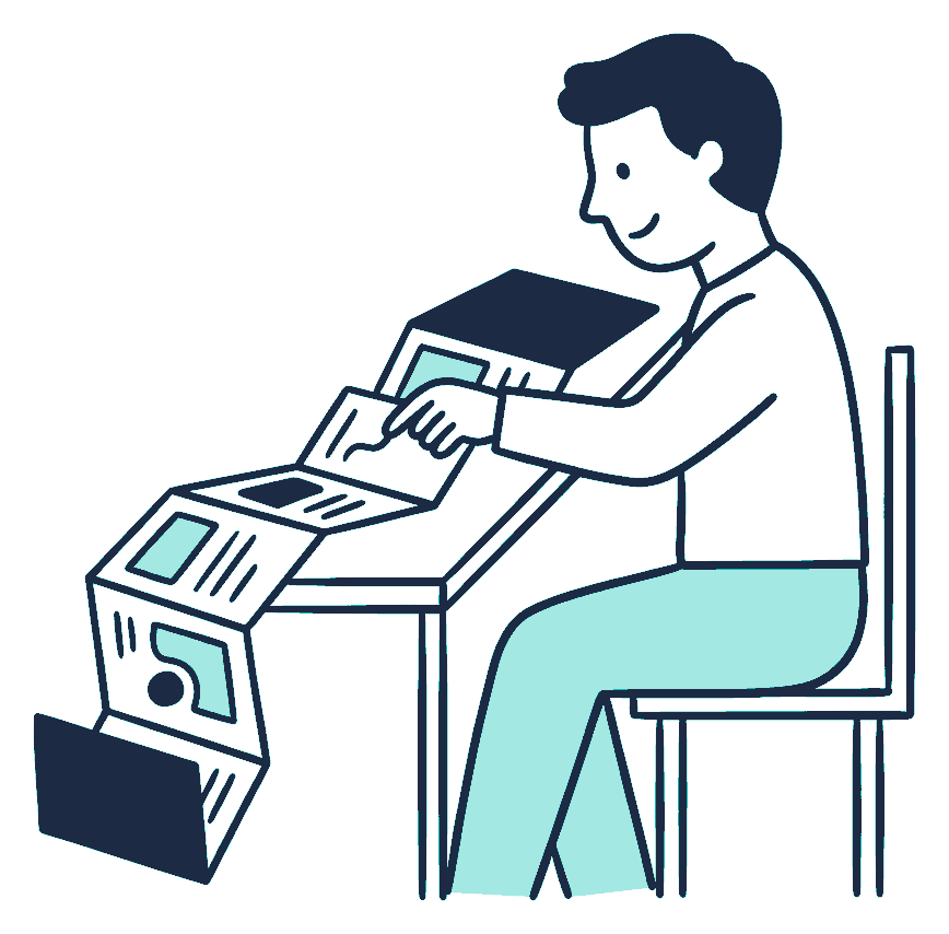 A seated person unfolds a long accordion-fold booklet across a table, tracing one line with a finger