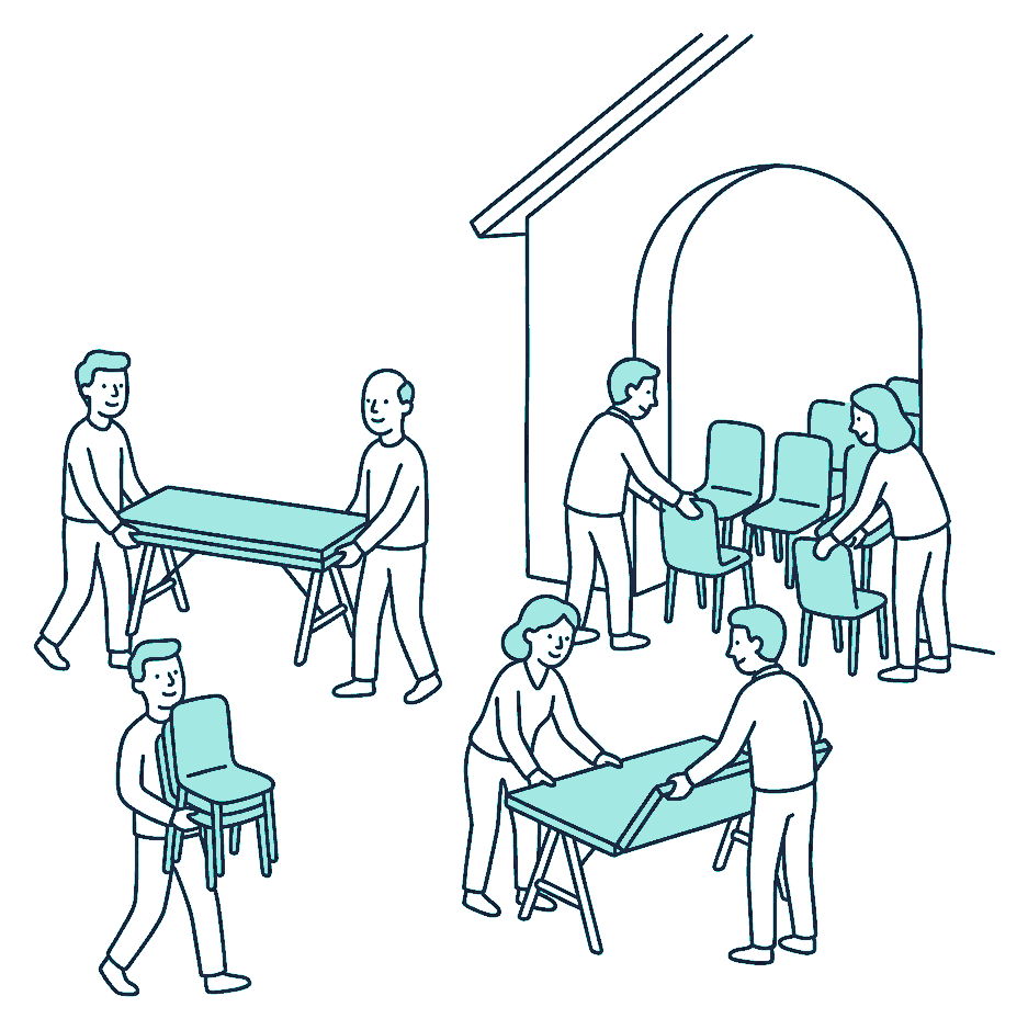 People carry trestle tables and stacked chairs into a large meeting house, setting them out in rows