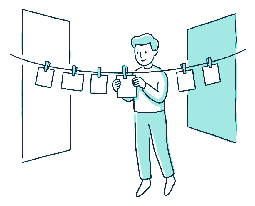 A traveller pegs small blank cards along a washing line strung across a wall, spacing them evenly