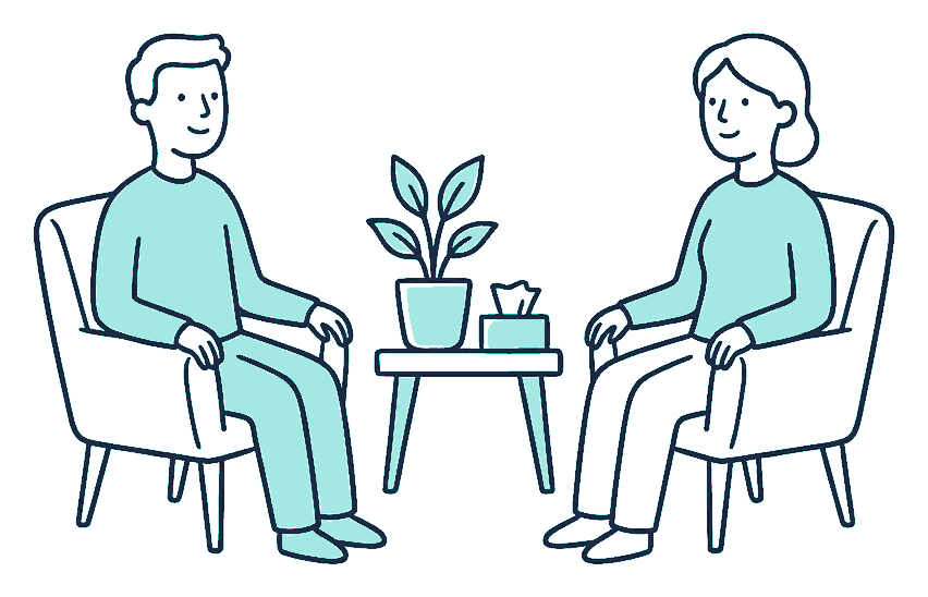 Two people sit facing each other in armchairs beside a potted plant and a small tissue box