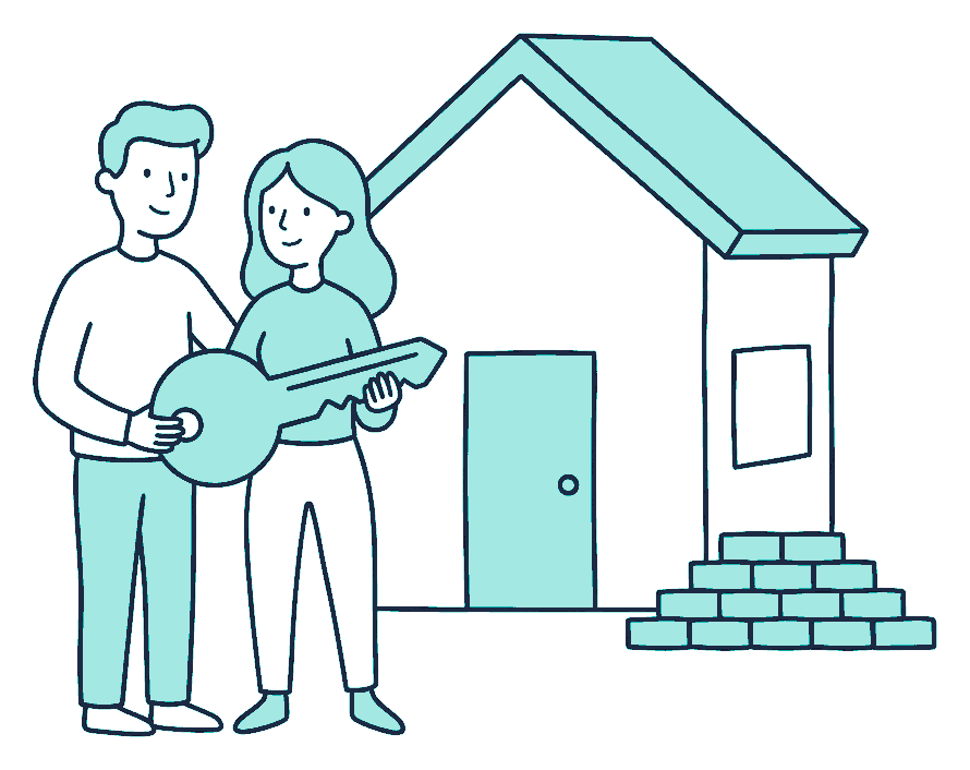 A couple holding a large house key in front of a small house with bricks stacked beside it