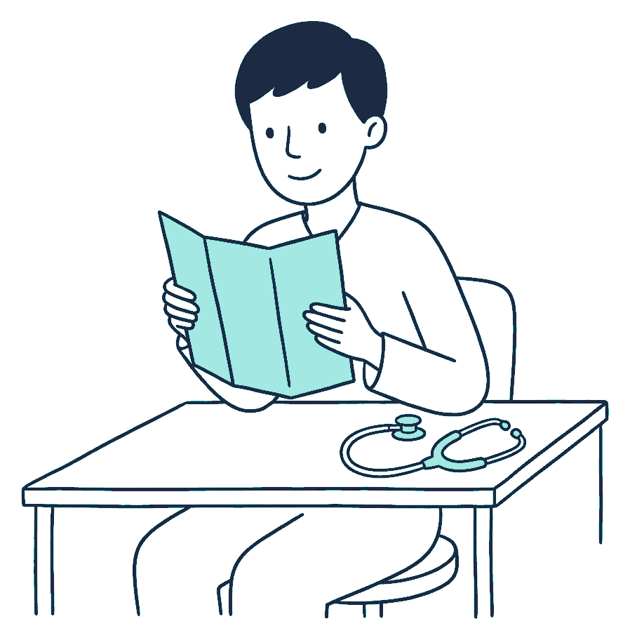 A person at a desk reading a pamphlet with a stethoscope beside them
